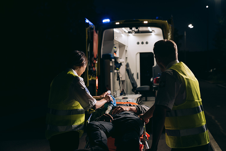 Ambulance attendants with injured worker.